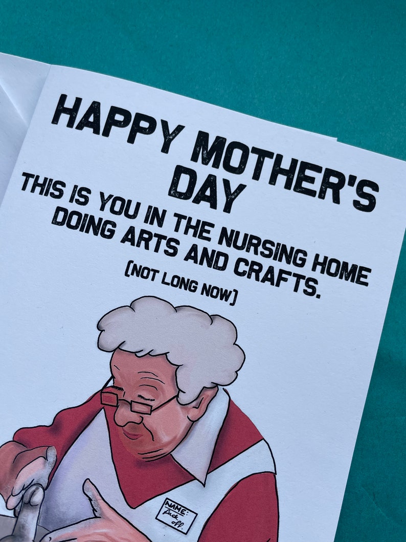 May include: A humorous greeting card with a cartoon illustration of an older woman in a red shirt and white apron, making pottery. The card reads "Happy Mother's Day. This is you in the nursing home doing arts and crafts. (Not long now)"