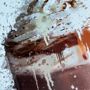 Puede incluir: Un primer plano de un batido de chocolate con crema batida y virutas de chocolate. El batido est&aacute; en un vaso con un fondo marr&oacute;n. La imagen tiene un efecto acuarela con salpicaduras blancas y marrones.
