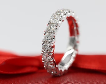 May include: A white gold diamond eternity band with a pave setting. The band is set with round brilliant diamonds that are closely set together.