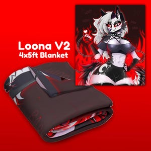 Op de afbeelding: Een opgevouwen deken met een cartoonillustratie van een wolfachtig personage, met de tekst "Loona V2 4x5ft Blanket". De deken is voornamelijk donkerbruin met rode en witte accenten. De illustratie toont een personage met witte en zwarte vacht.