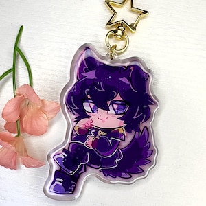 May include: A purple and black anime-style character keychain with a gold chain. The character has a purple and black wolf tail and is wearing a black and purple outfit.