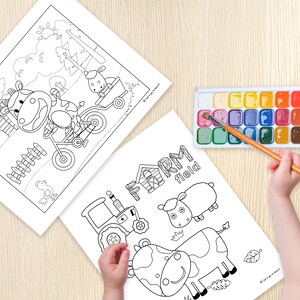 以下が含まれることがあります： 農場の動物が描かれた白黒の塗り絵2枚。1枚目は自転車に乗った牛、鶏、納屋が描かれている。2枚目は牛、羊、トラクター、そして「FARM field」という文字が描かれている。