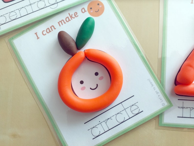 Peut inclure: Une carte blanche avec une bordure verte et le texte "Je peux faire un cercle" imprim&eacute; dessus. Un orange en p&acirc;te &agrave; modeler avec un visage souriant et des feuilles vertes est sur la carte. Le mot "cercle" est &eacute;crit en cursive sur une ligne sous l'orange.