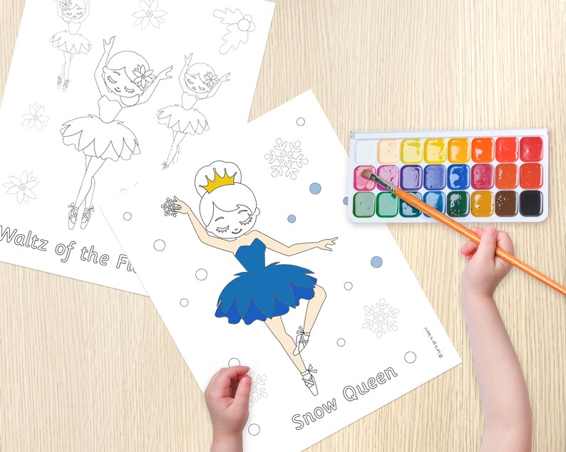 May include: Two coloring pages featuring ballerina illustrations. The first page shows a ballerina with a flower in her hair and the text "Waltz of the Flowers". The second page shows a ballerina with a crown and the text "Snow Queen". A watercolor paint set and a paintbrush are also visible.