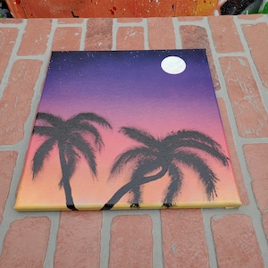 May include: A painting of a sunset with two palm trees and a full moon in the sky. The sky is a gradient of purple, pink, and orange. The palm trees are black silhouettes against the sunset.