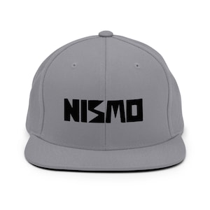 May include: A gray and black NISMO logo embroidered on a gray fitted baseball cap.