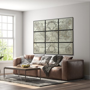 Pu&ograve; includere: Un divano in pelle marrone con una coperta e cuscini davanti a un muro con una grande stampa di mappa del mondo incorniciata. La mappa &egrave; divisa in nove sezioni ed &egrave; in bianco e nero.