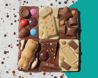May include: A collection of six assorted chocolate squares. Each square features a different flavor and topping, including a biscuit, a chocolate bar, and a candy bar. The squares are arranged in a grid pattern.