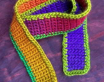 Rainbow-coloured crocheted scarf for dolls and teddybears, vibrant coloures. Measurements 68cm x 4cm.