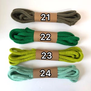 May include: Four bundles of colorful rope, each wrapped with a brown paper band and labeled with a number. The colors include olive green (21), bright green (22), lime green (23), and seafoam green (24).