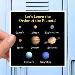 May include: A white sticker featuring the text "Let's Learn the Order of the Planets!" and planet illustrations. The planets are humorously labelled "Mary's", "Virgin", and "Suspect". The sticker is held in front of a blue locker.