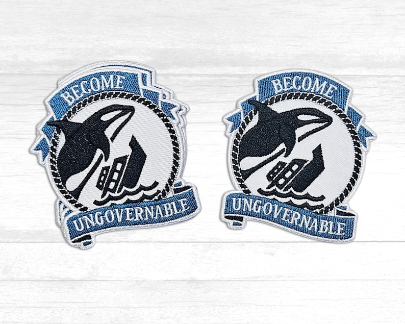 May include: Two blue and white embroidered patches with the text "Become Ungovernable" and a black silhouette of an orca whale jumping over a sinking ship.