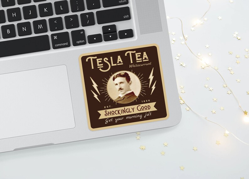 May include: A brown and beige sticker on a laptop featuring the text "TESLA TEA Whitecurrant" with an image of Nikola Tesla. The sticker also includes the text "SHOCKINGLY GOOD" and "Get your morning jolt."