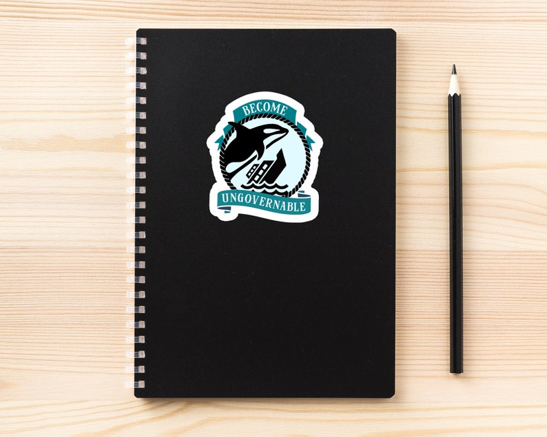 May include: A black notebook with a spiral binding and a sticker on the front. The sticker is teal blue and white and features a black orca jumping over a ship. The sticker says "Become Ungovernable".