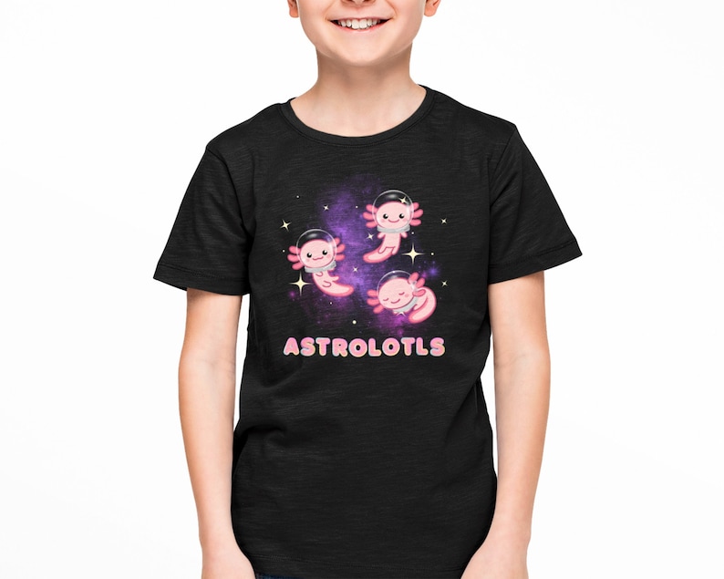 K&ouml;nnte beinhalten: Schwarzes T-Shirt mit einem Galaxie-Druck, auf dem drei rosa Axolotl mit Astronautenhelmen zu sehen sind. Der Text "ASTROLOTLS" ist in rosa und blauen Buchstaben unter den Axolotln gedruckt.