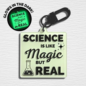 May include: A square, glow-in-the-dark keychain with the text "SCIENCE IS LIKE Magic BUT REAL" in black lettering. The keychain has a black clasp and a light green background. The words "GLOWS IN THE DARK" are in a circle at the top.