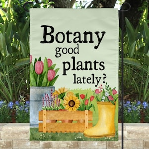 Peut inclure: Un drapeau de jardin vert avec une illustration aquarelle de fleurs dans des pots et une caisse en bois. Le texte sur le drapeau est "Botany good plants lately?"