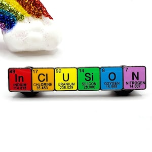 Op de afbeelding: Een kleurrijke emaille pin die het woord "inclusie" spelt met behulp van de chemische symbolen voor de elementen indium, chloor, uranium, silicium, zuurstof en stikstof. Elk elementsymbool wordt weergegeven op een vierkant in een andere kleur.