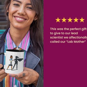 Op de afbeelding: Een witte koffiemok met een zwarte rand en handvat. De mok heeft een zwart-witte illustratie van twee vrouwen, een draagt een labjas en de andere een superheldencape. De tekst "Lab Mother" is niet zichtbaar op de afbeelding.