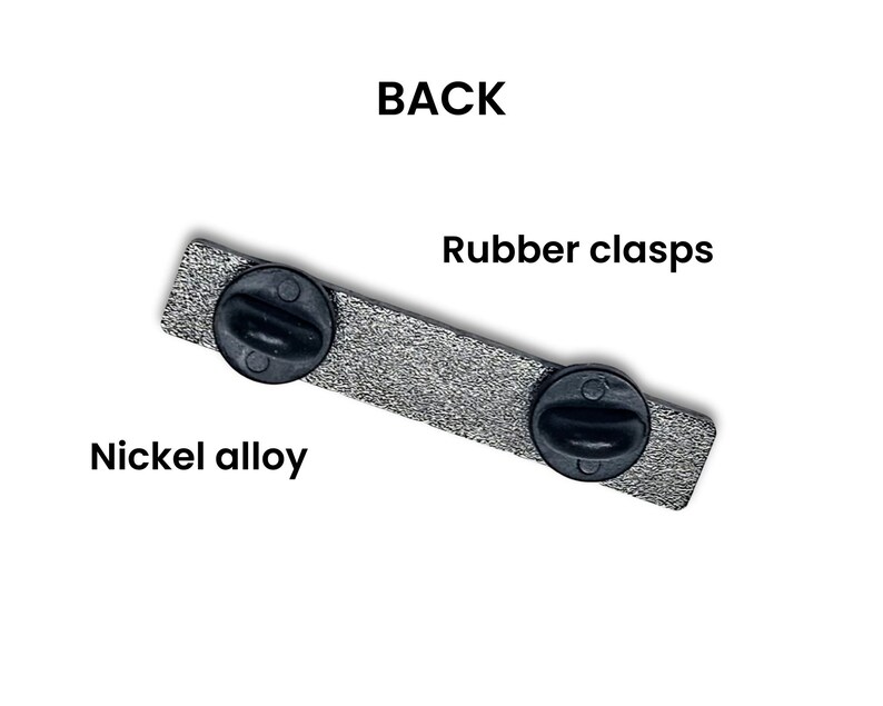 May include: The back of a silver pin with two black rubber clasps. The pin is made of nickel alloy.