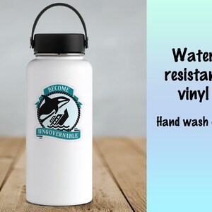 May include: White water bottle with a black lid and handle. A sticker with a black orca jumping out of the water and a sinking ship is on the bottle. The sticker says "Become Ungovernable".