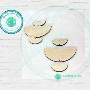 May include: Set of three unfinished wooden half-circle earrings. The earrings are different sizes and have holes for hanging. The earrings are on a white wooden background.