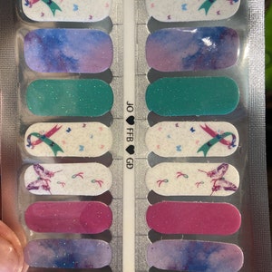 May include: A set of 12 nail wraps featuring a variety of designs, including butterflies, ribbons, and watercolor-like patterns. The nail wraps are packaged in a clear plastic pouch with the text "JO ♥ FB GD" printed on the side.