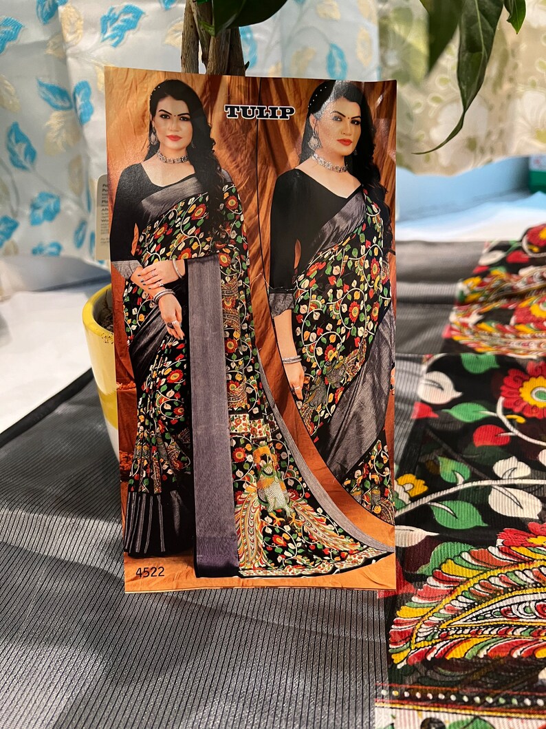May include: A black and gray saree with a floral print. The saree has a silver border and a black blouse. The image also includes the text "TULIP" and "4522".