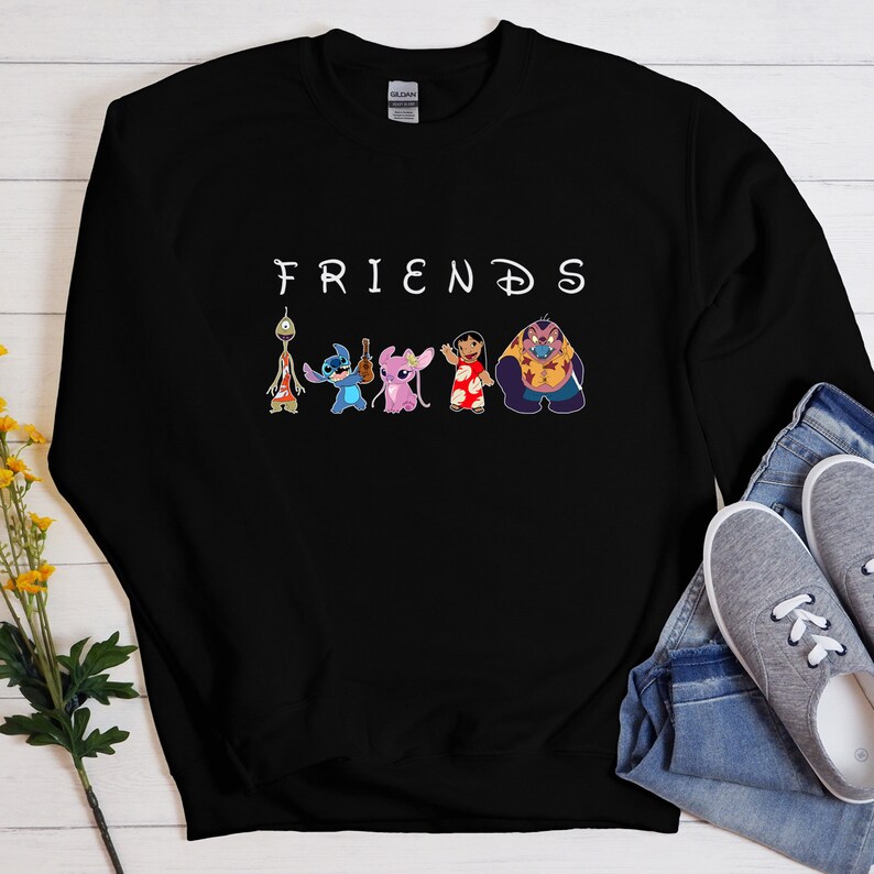 Puede incluir: Sudadera negra con la palabra "FRIENDS" en letras blancas y una l&iacute;nea de personajes de dibujos animados de la pel&iacute;cula de Disney Lilo & Stitch. Los personajes incluyen a Stitch, Angel, Lilo y Jumba.