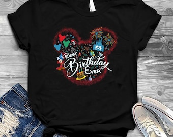 Peut inclure: T-shirt noir avec une silhouette rouge de tête de Mickey Mouse. La silhouette est remplie de personnages Disney colorés et du texte "Best Birthday Ever".