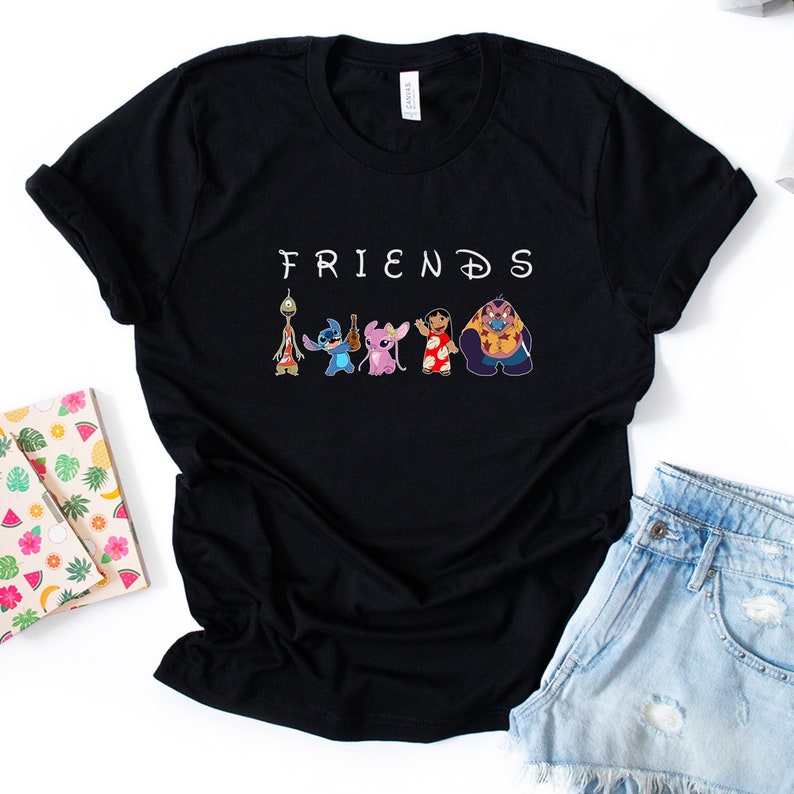 Puede incluir: Camiseta negra con la palabra "FRIENDS" en letras blancas y una l&iacute;nea de personajes de dibujos animados de la pel&iacute;cula Lilo & Stitch. Los personajes incluyen a Stitch, Jumba, Pleakley, Angel y el Experimento 626.