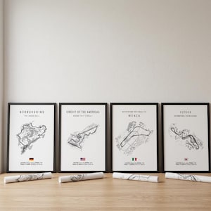 Puede incluir: Cuatro mapas de circuitos de carreras en blanco y negro enmarcados, incluyendo Nürburgring, Circuit of the Americas, Autodromo Nazionale di Monza y Suzuka. Cada mapa tiene una bandera y texto en la parte inferior. Mapas enrollados al frente.