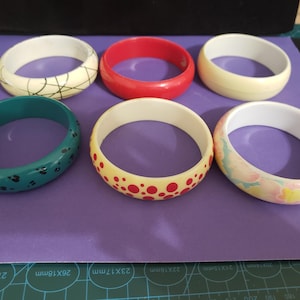 May include: A white ceramic mug with a black handle and the text "But First, Coffee" in a black, bold font. The mug is on a white surface.