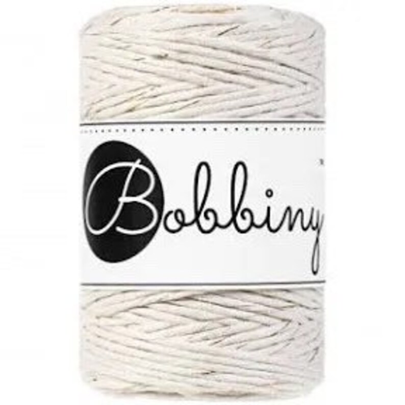 May include: A spool of natural-colored cotton twine with a white label that says "Bobbiny".
