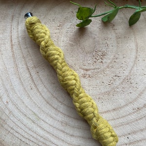 May include: A yellow braided pen with a clear plastic top and a metal tip.