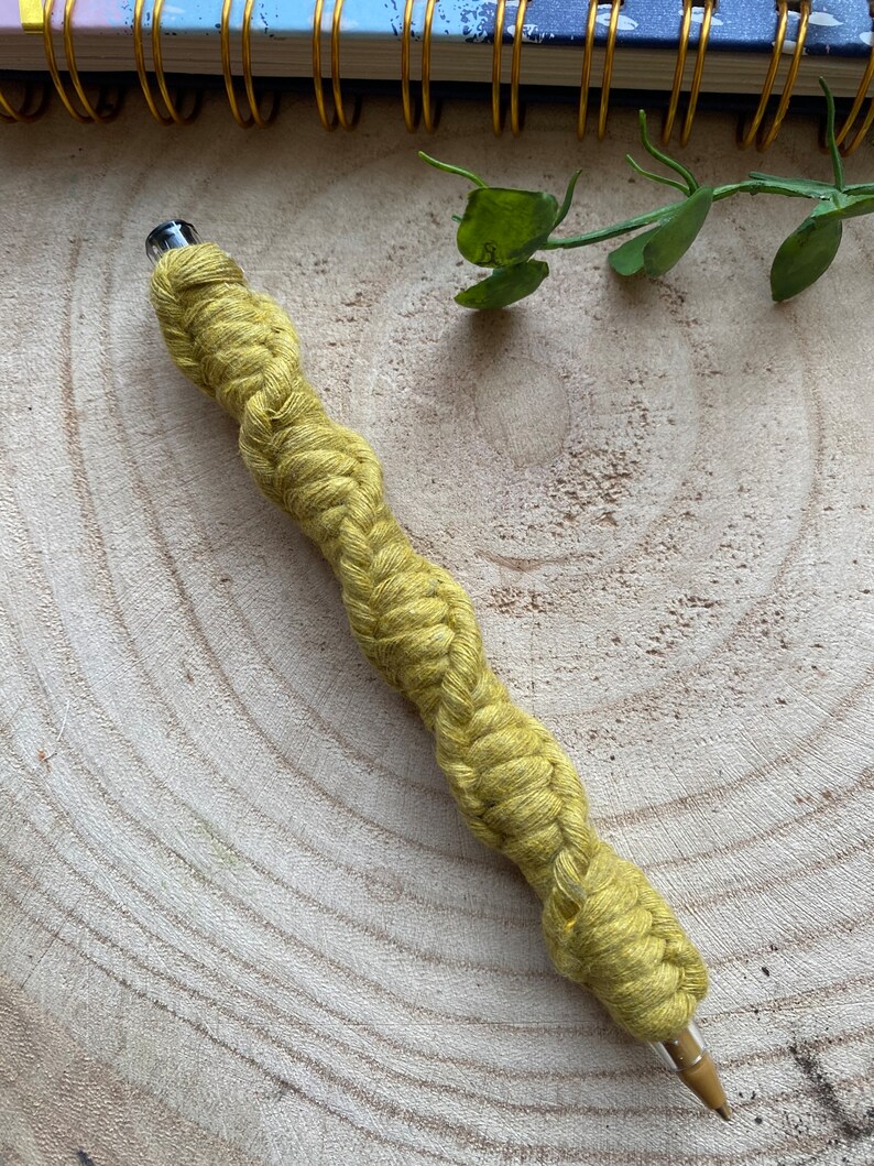 May include: A yellow braided pen with a clear plastic top and a metal tip.