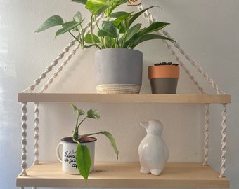 May include: Two wooden shelves with rope hangers, featuring a potted plant, a small potted succulent, a white ceramic penguin figurine, and a white mug with the text "Live your life up" on a white background.