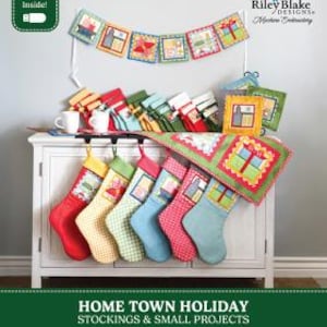 May include: A collection of fabric Christmas stockings and small quilted projects featuring colorful patterns and house motifs. The set includes a USB drive, with text reading Riley Blake Designs, Home Town Holiday Stockings & Small Projects, and By Lori Holt of Bee in my Bonnet.
