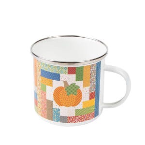 May include: White enamel mug with a patchwork design featuring a pumpkin in the center. The mug has a silver rim and a handle.