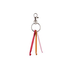 May include: A set of three colorful crochet hooks attached to a silver keychain. The hooks are in shades of red, orange, and pink. The hooks are made of metal and have a curved end for catching yarn.