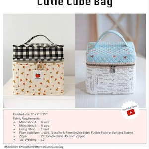 May include: Two "Cutie Cube Bag" designs are shown. One is cream-colored with a strawberry pattern, the other is light blue with a floral pattern. Both have a cube shape, a zipper closure, and a handle. The finished size is 9" x 9" x 8¾".