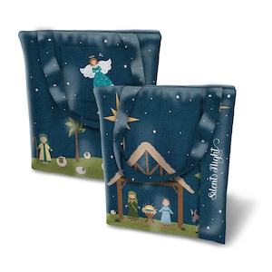 May include: Two blue tote bags with Christmas scenes. The first bag features an angel with a halo and stars. The second bag features a nativity scene with a stable, a donkey, a sheep, and the text "Silent Night".