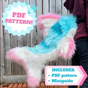 Puede incluir: Una cola de piel sintética de pelo largo en blanco, rosa brillante y azul cian. La imagen incluye el texto PDF PATTERN! y INCLUDES: PDF pattern, Miniguide. La cola tiene una base ancha y una punta, con una textura suave y peluda.