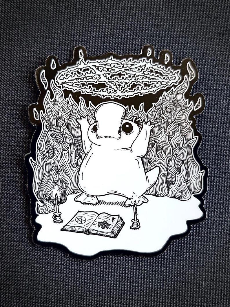 May include: A black and white illustration of a platypus performing a ritual. The platypus is standing on a pentagram with two candles on either side. The platypus is holding its arms up in the air, and a circle of fire is above its head. The platypus is wearing a crown.