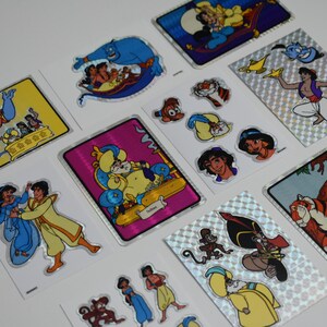 May include: A set of 10 Aladdin themed stickers featuring characters like Genie, Jasmine, Aladdin, Abu, and Rajah. The stickers are holographic and have a shiny finish.