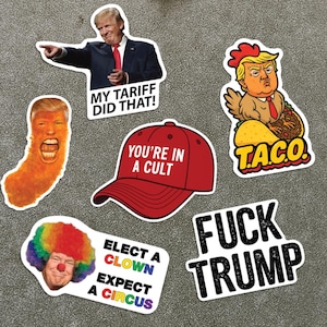 May include: A metal sign with several political stickers. The stickers feature images of Donald Trump and various slogans, including "MY TARIFF DID THAT!", "YOU'RE IN A CULT", and "FUCK TRUMP". Other stickers include a clown and a chicken.