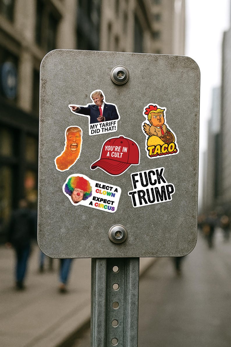 May include: A metal sign with several political stickers. The stickers feature images of Donald Trump and various slogans, including "MY TARIFF DID THAT!", "YOU'RE IN A CULT", and "FUCK TRUMP". Other stickers include a clown and a chicken.