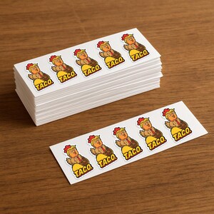 May include: A stack of white rectangular stickers featuring a cartoon image of a person with orange hair and a red tie, resembling a chicken, sitting in a taco shell. The word "TACO" is printed below each image.