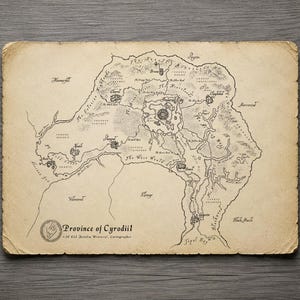May include: A rectangular parchment map of the Province of Cyrodiil with deckled edges. The map features black ink illustrations of mountains, rivers, and forests, with labels for various regions and cities. The text reads Province of Cyrodiil.