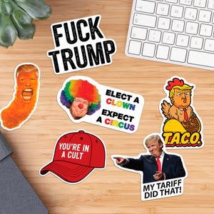 May include: A collection of political stickers with various designs and text. One sticker reads "FUCK TRUMP" in bold black letters. Other stickers include images of a clown, a taco, and a red baseball cap with the text "YOU'RE IN A CULT".